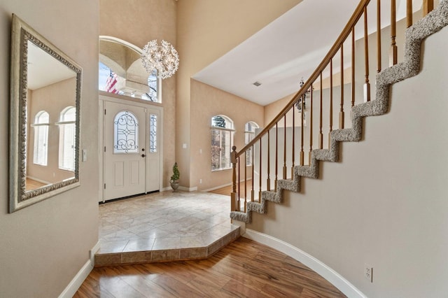 entryway with visible vents, stairs, baseboards, and wood finished floors