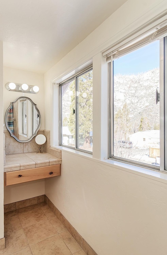 bathroom with a healthy amount of sunlight, tile patterned flooring, and baseboards