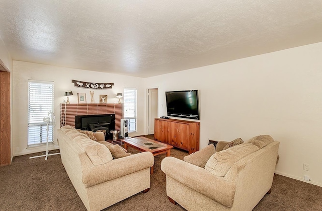 living area with baseboards, dark carpet, and a textured ceiling