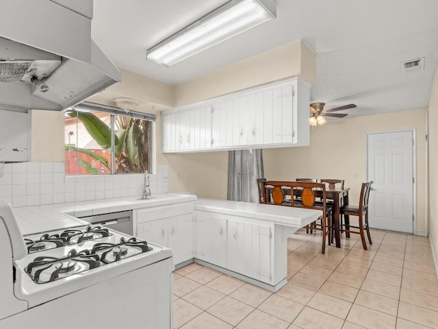 2103 N Price Ave Unit 106, Fresno, CA 93703 - kitchen featuring tile counters, white gas stove, a peninsula, and light tile patterned floors