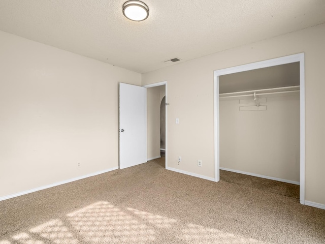2103 N Price Ave Unit 106, Fresno, CA 93703 - unfurnished bedroom with carpet flooring, a closet, arched walkways, a textured ceiling, and baseboards