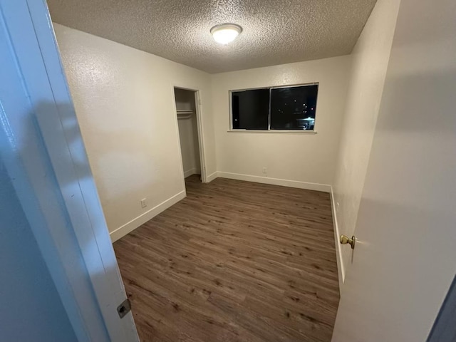 2004 E White Ave, Fresno, CA 93701 - unfurnished bedroom featuring a textured ceiling, wood finished floors, a closet, and baseboards
