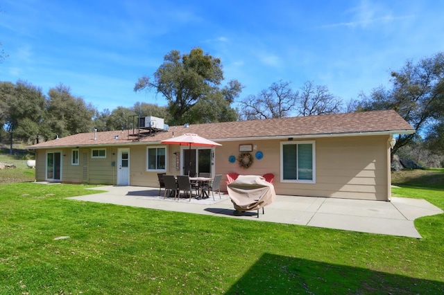 back of property with a yard and a patio area