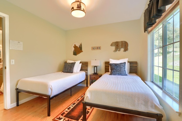 bedroom featuring light wood-style flooring and baseboards