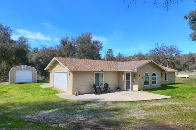 rear view of property with a yard, a storage shed, an outbuilding, and a patio