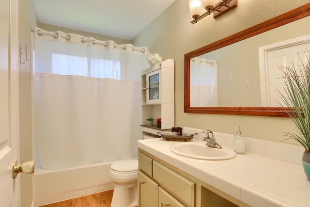 bathroom with shower / bath combination with curtain, vanity, toilet, and wood finished floors