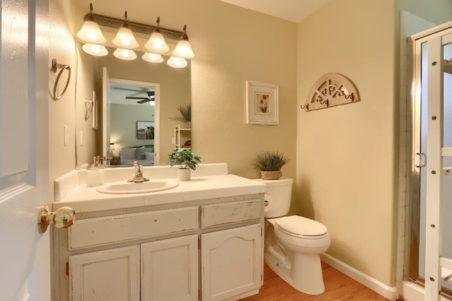 full bath with toilet, a stall shower, vanity, ensuite bath, and wood finished floors