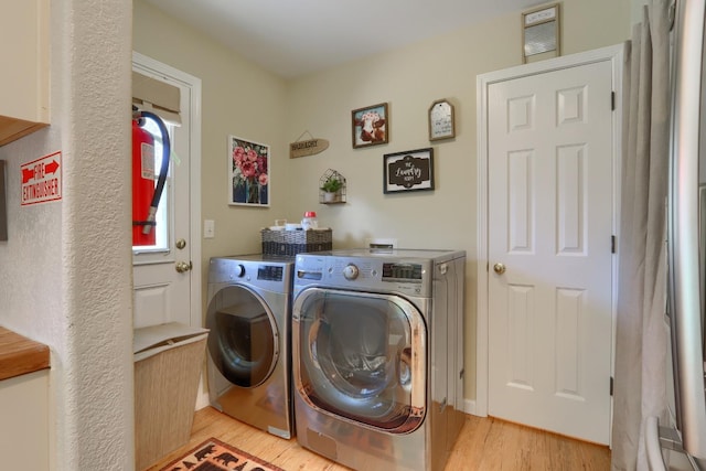 laundry room with laundry area, light wood-style floors, and washing machine and clothes dryer