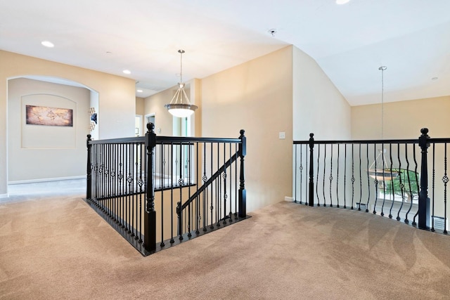 hall featuring carpet floors, recessed lighting, vaulted ceiling, and an upstairs landing