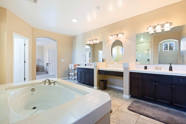 full bathroom with a bath, two vanities, tile patterned flooring, walk in shower, and a sink