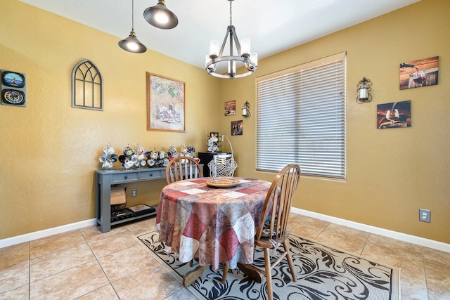 dining area featuring light tile patterned floors, baseboards, and a notable chandelier