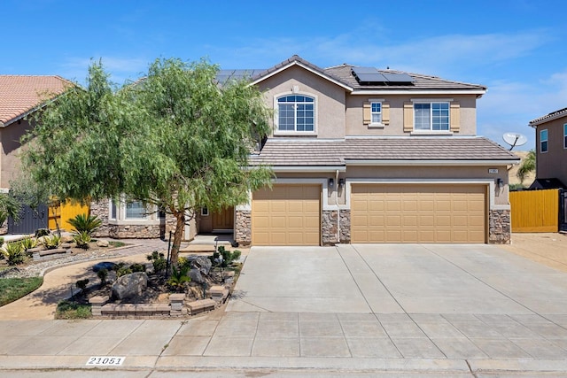 view of front of home with stone siding, concrete driveway, a tiled roof, and stucco siding