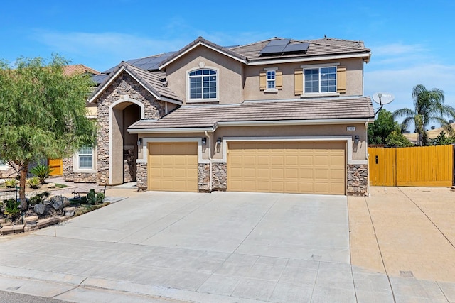 view of front of property with a tile roof, stucco siding, fence, a garage, and driveway