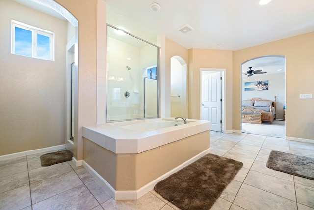 ensuite bathroom featuring a stall shower, ensuite bath, tile patterned flooring, baseboards, and a bath