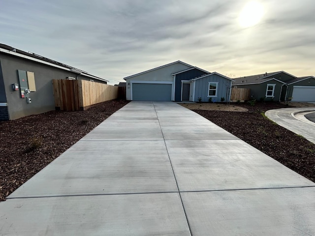 view of front of house featuring driveway, a garage, fence, and board and batten siding