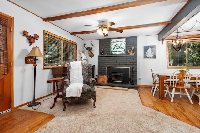 interior space with beam ceiling, carpet flooring, wood finished floors, baseboards, and ceiling fan with notable chandelier