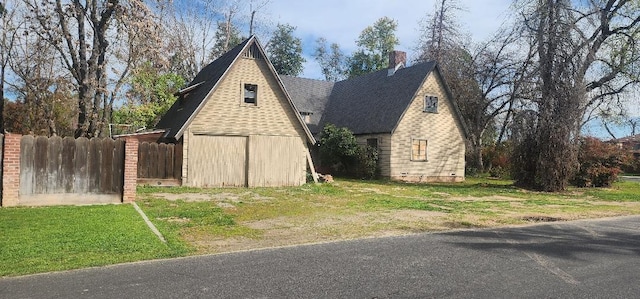 view of side of home with fence and a lawn