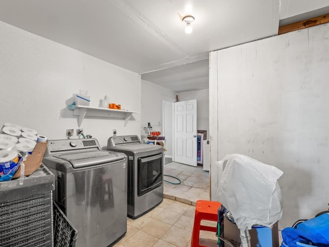 laundry area with laundry area, washer and clothes dryer, and light tile patterned flooring