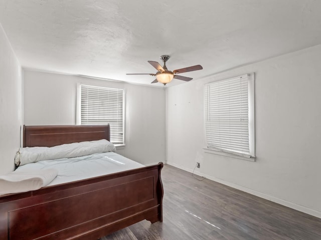 bedroom featuring ceiling fan, baseboards, and wood finished floors