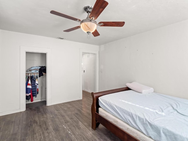 bedroom with baseboards, visible vents, ceiling fan, wood finished floors, and a closet