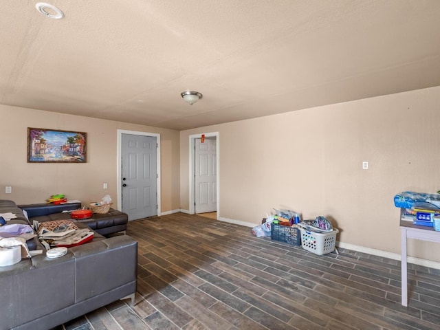 living room featuring a textured ceiling, wood finished floors, and baseboards