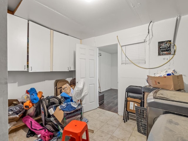 laundry area with light tile patterned flooring and cabinet space