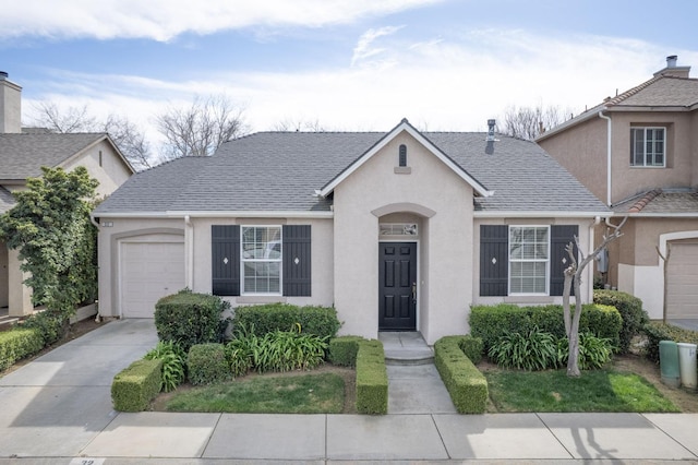 view of front of house with driveway, a shingled roof, an attached garage, and stucco siding