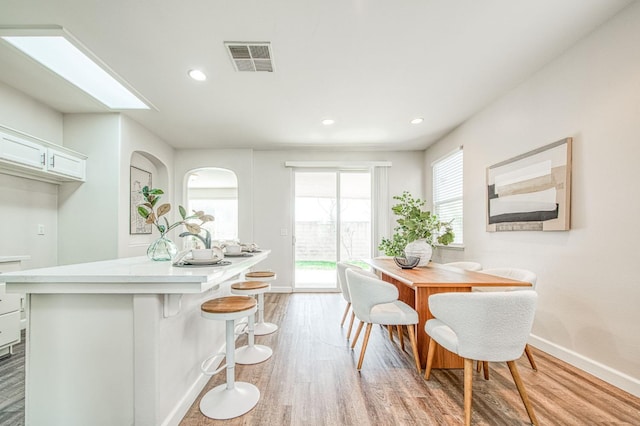 dining space with light wood-style floors, recessed lighting, visible vents, and baseboards