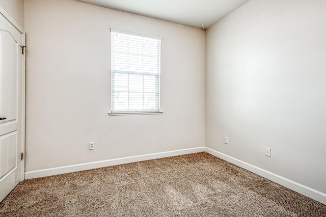 unfurnished room featuring carpet floors and baseboards