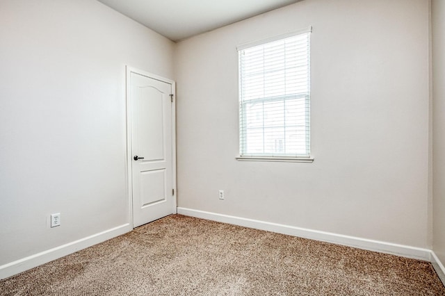 carpeted empty room with baseboards