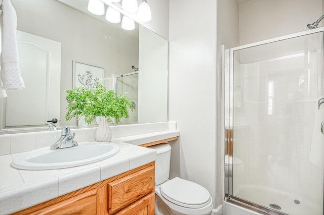 full bath featuring toilet, a stall shower, and vanity