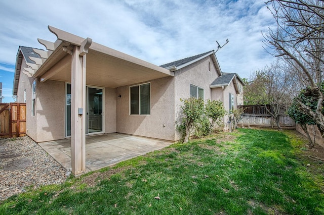 back of property with a fenced backyard, a lawn, and stucco siding