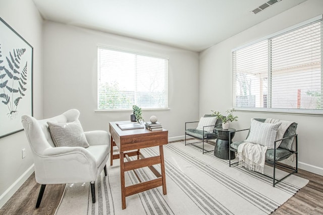 sitting room featuring visible vents, baseboards, and wood finished floors