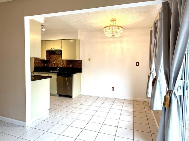 kitchen with dark countertops, light tile patterned floors, backsplash, and stainless steel dishwasher