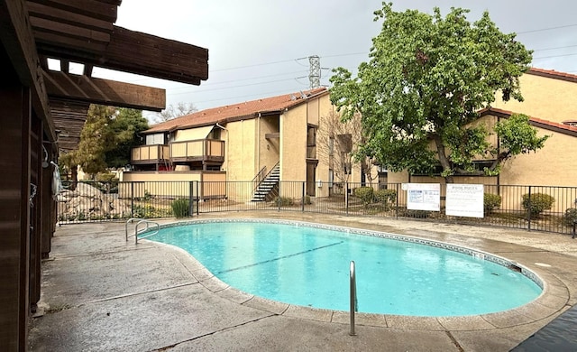 pool featuring a patio area and fence