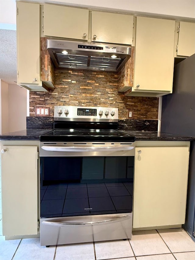 kitchen featuring light tile patterned floors, tasteful backsplash, electric range, freestanding refrigerator, and ventilation hood