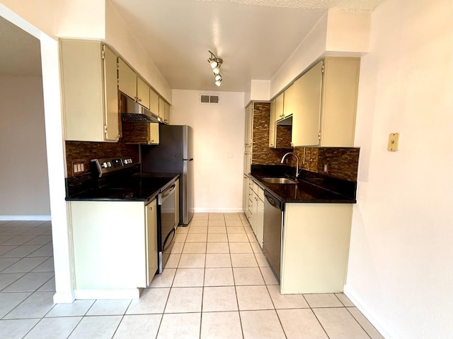 kitchen with light tile patterned floors, visible vents, dark countertops, stainless steel appliances, and a sink