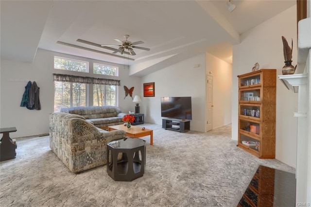 living room featuring carpet floors, a tray ceiling, and a ceiling fan