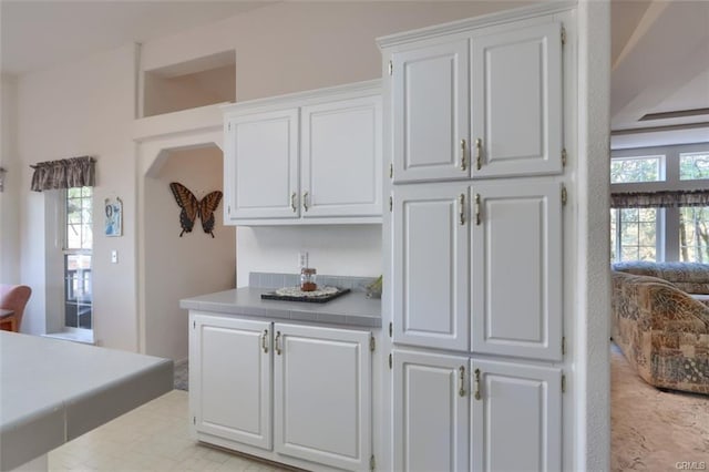 kitchen with tile countertops and white cabinets