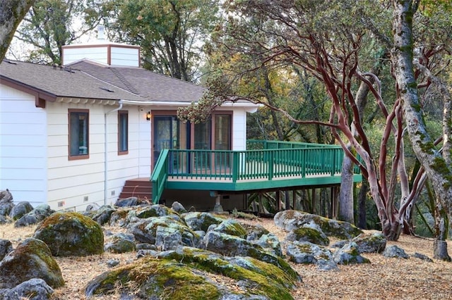 exterior space featuring crawl space, a wooden deck, and roof with shingles