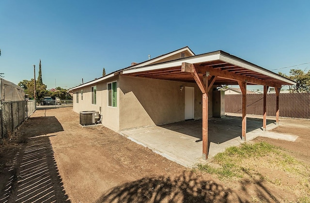 view of patio / terrace with a carport, central AC, and fence