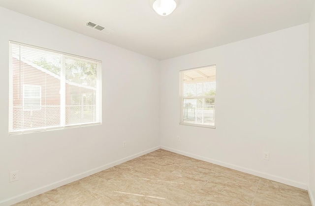 unfurnished room featuring visible vents and baseboards