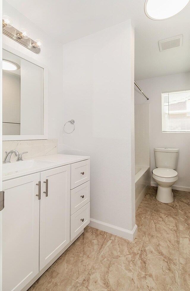 bathroom featuring visible vents, shower / bathing tub combination, toilet, vanity, and baseboards