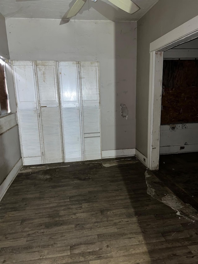 empty room featuring ceiling fan, baseboards, and wood finished floors