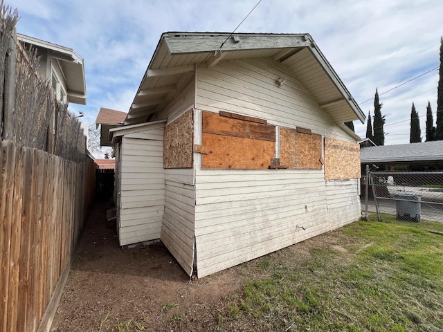 view of side of property with fence and a lawn