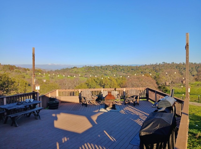 wooden terrace featuring a wooded view