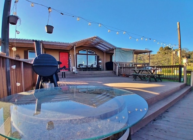 back of property with a tile roof, a deck, and stucco siding