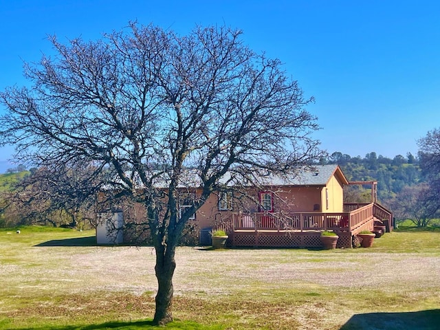 exterior space featuring a front lawn and a wooden deck