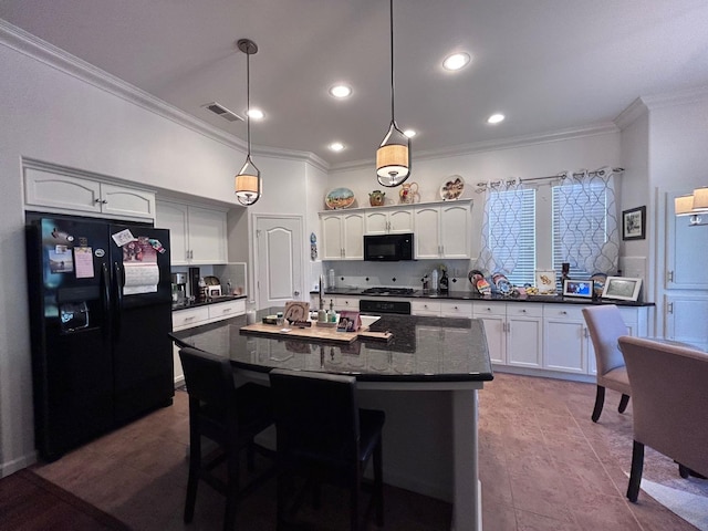 kitchen featuring pendant lighting, backsplash, white cabinets, an island with sink, and black appliances