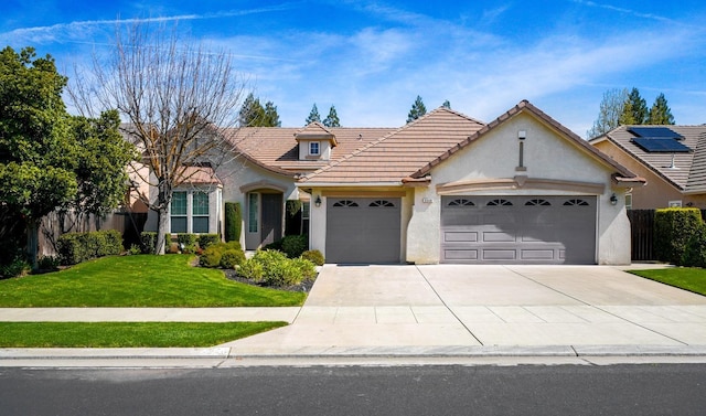 view of front of property with stucco siding, a front yard, a tile roof, a garage, and driveway